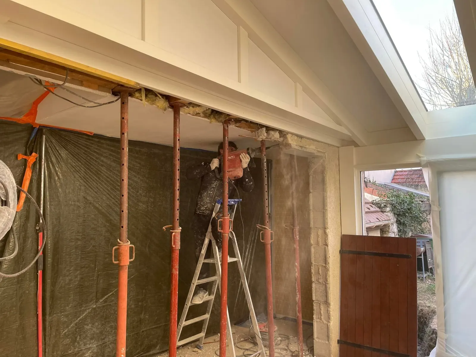 Le mur porteur sous étais pendant son ouverture, un maçon sur l’escabeau