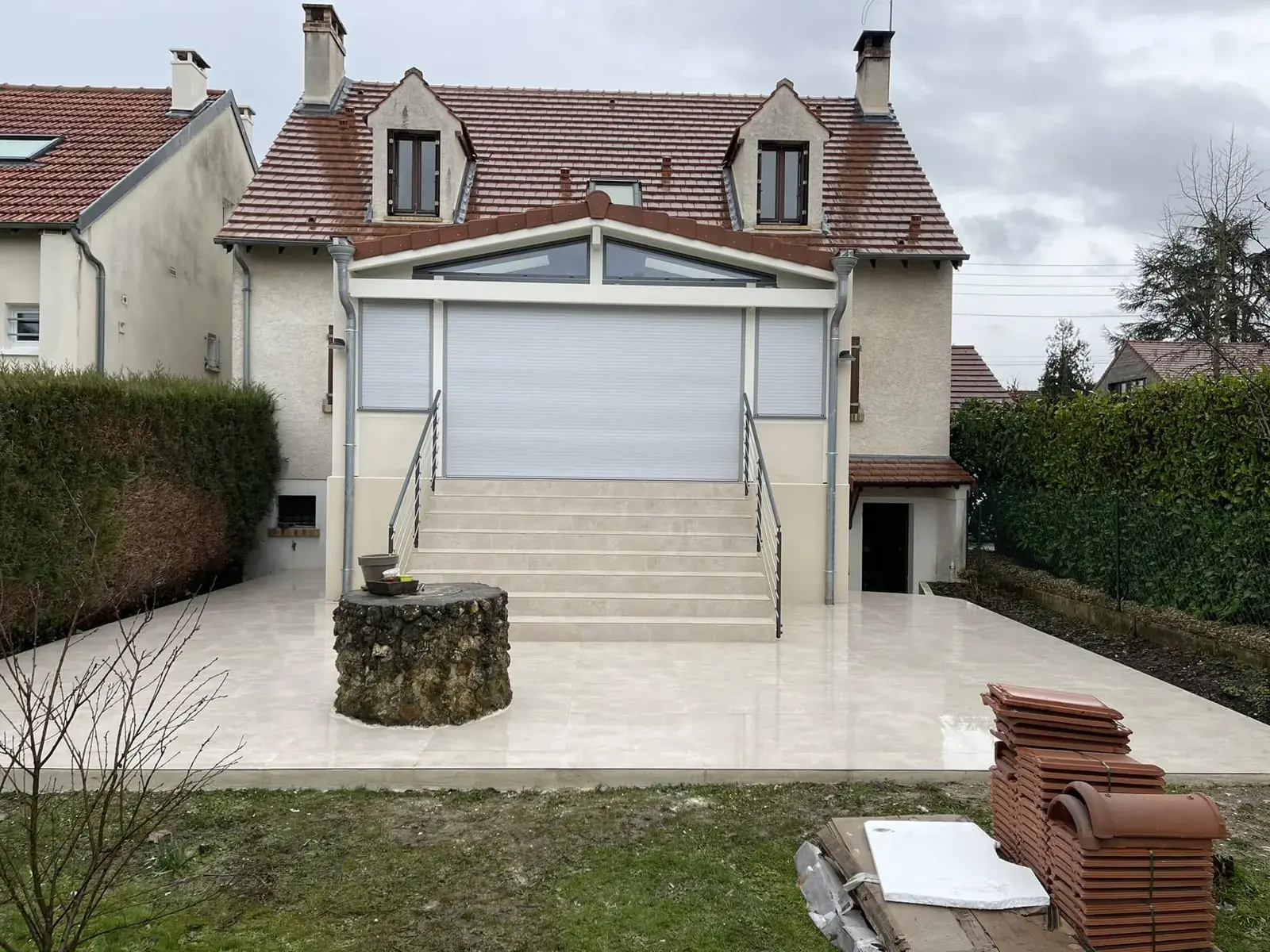 Terrasse carrelée et escalier d’entrée finis, toute la maison derrière