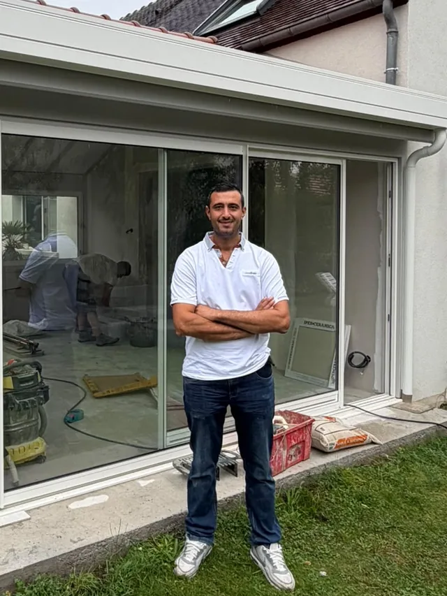 Serkan Baskan, gérant de Baskan78, devant une véranda en cours de finition